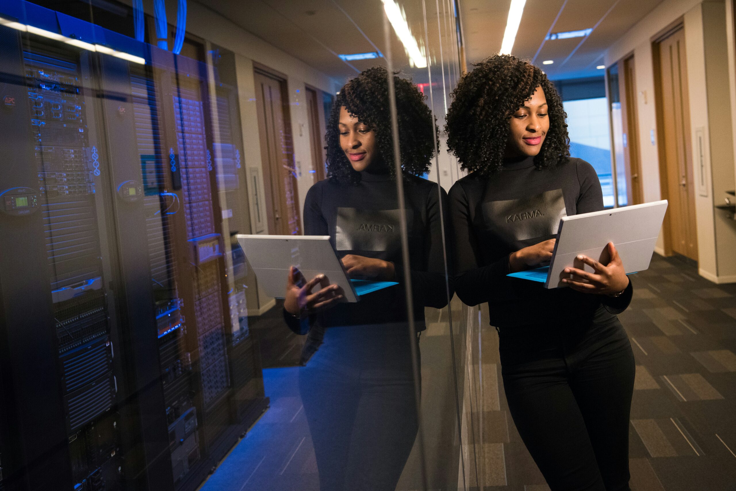 A professional woman holding a laptop, representing the integration of Umunthu-inspired leadership and modern digital strategy at Jacob’s Ladder Ltd.